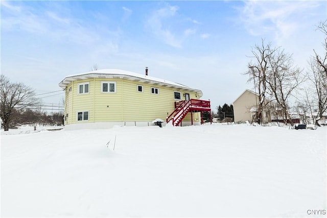 snow covered house with a wooden deck