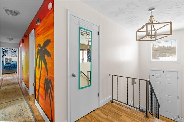 hall featuring hardwood / wood-style flooring and an inviting chandelier