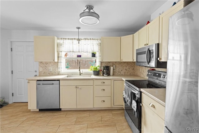 kitchen with pendant lighting, sink, stainless steel appliances, and tasteful backsplash