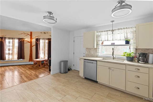 kitchen featuring tasteful backsplash, baseboard heating, sink, cream cabinets, and dishwasher