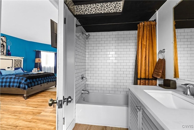 bathroom with wood-type flooring, vanity, and shower / bath combo