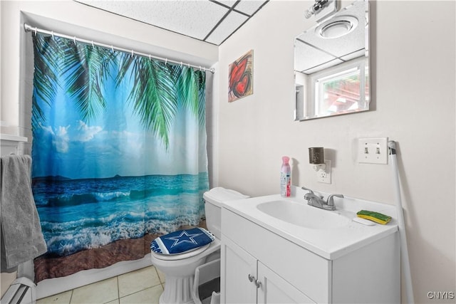 bathroom with a paneled ceiling, tile patterned floors, vanity, a baseboard radiator, and toilet