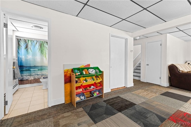 game room featuring light tile patterned floors, a paneled ceiling, and a baseboard radiator