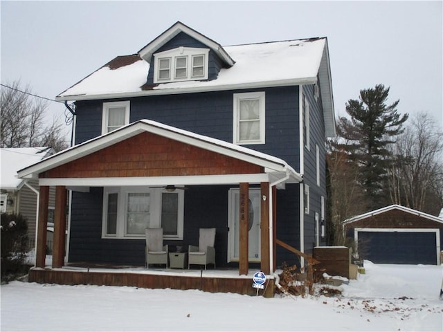 view of front of house featuring a porch, a garage, and an outbuilding