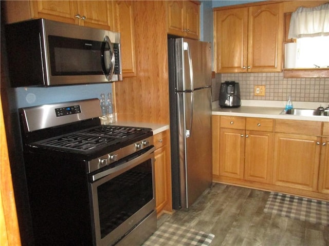 kitchen with hardwood / wood-style flooring, decorative backsplash, sink, and stainless steel appliances