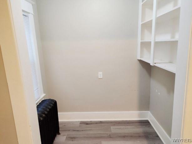 laundry room with radiator heating unit and wood-type flooring