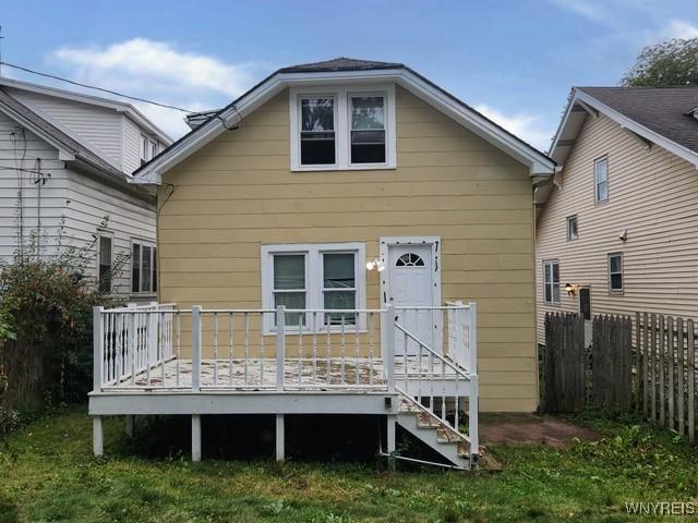 rear view of house featuring a yard and a wooden deck