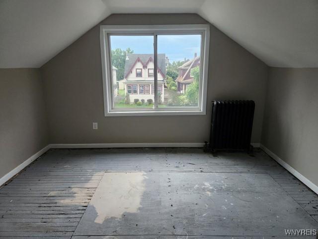 bonus room featuring radiator and vaulted ceiling