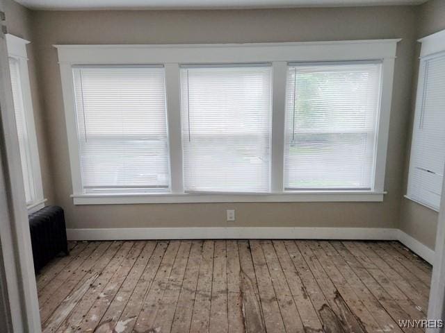 empty room featuring light wood-type flooring and radiator