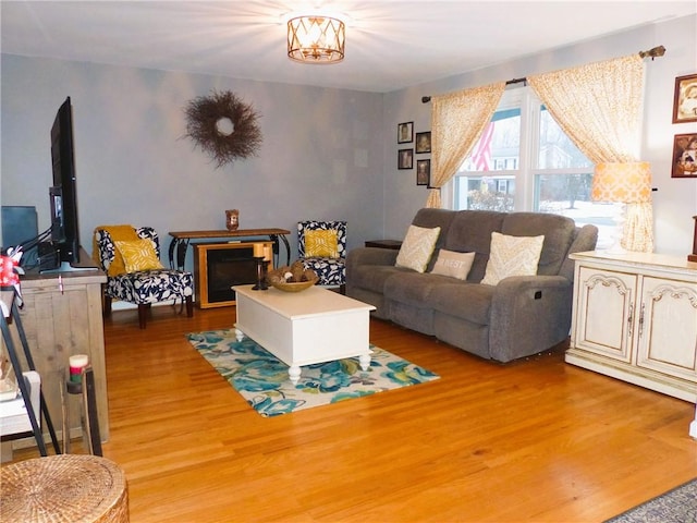 living room with light wood-type flooring and a notable chandelier