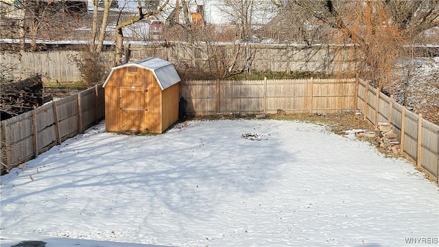 yard layered in snow featuring a shed