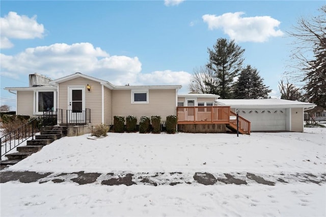 snow covered property with a garage