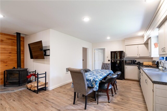 9539 Bronson Rd, Dansville, NY 14572 - dining room featuring sink, light wood-type flooring, and a wood stove