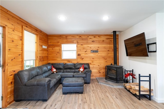 9539 Bronson Rd, Dansville, NY 14572 - living room with wooden walls, a wood stove, and light hardwood / wood-style flooring