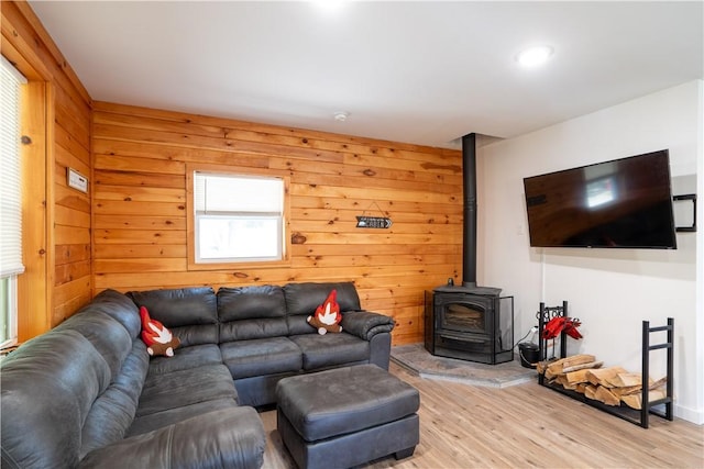 9539 Bronson Rd, Dansville, NY 14572 - living room featuring wood walls, a wood stove, and light hardwood / wood-style flooring