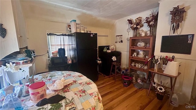 bedroom featuring black refrigerator and wood-type flooring