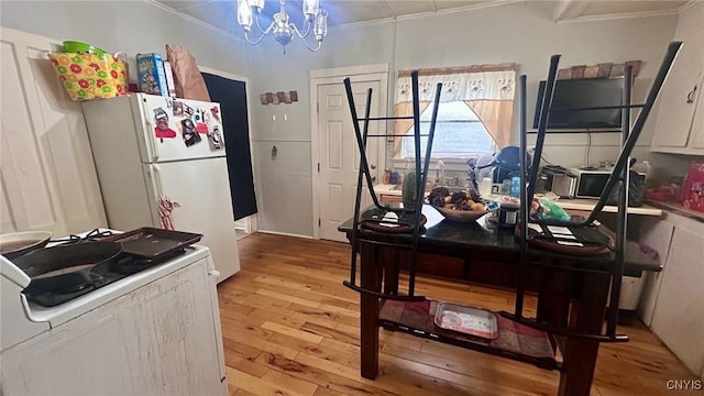 kitchen with white refrigerator, white cabinetry, ornamental molding, light hardwood / wood-style floors, and a notable chandelier