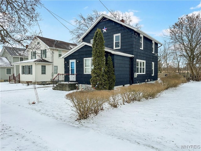 view of snow covered back of property