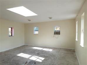 unfurnished room featuring a skylight