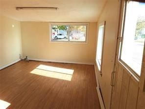 unfurnished room featuring basketball court, hardwood / wood-style floors, and a healthy amount of sunlight