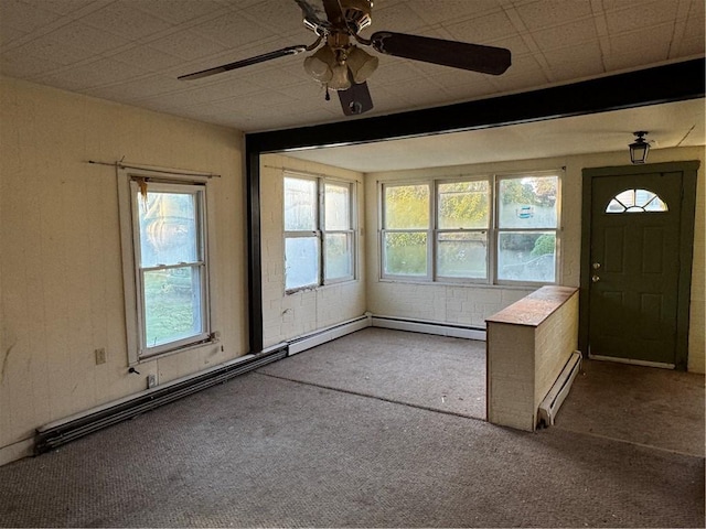 foyer entrance featuring baseboard heating, ceiling fan, carpet flooring, and plenty of natural light