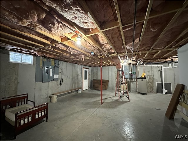 basement featuring water heater and electric panel