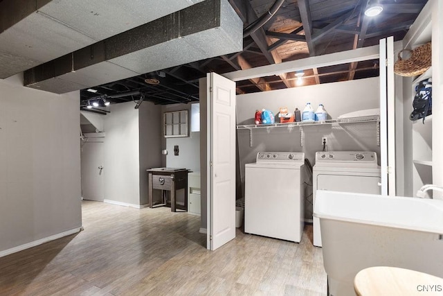 laundry room with independent washer and dryer, wood-type flooring, and sink