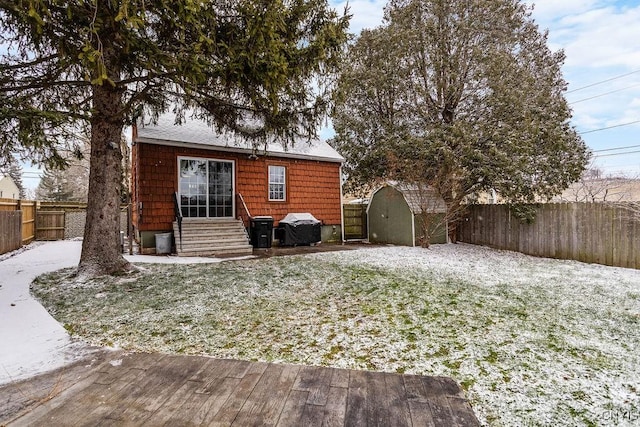 back of property featuring a yard and a storage shed