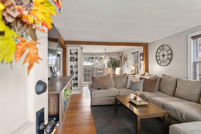 living room featuring beam ceiling and hardwood / wood-style floors