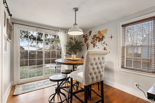 dining room with a barn door and dark wood-type flooring