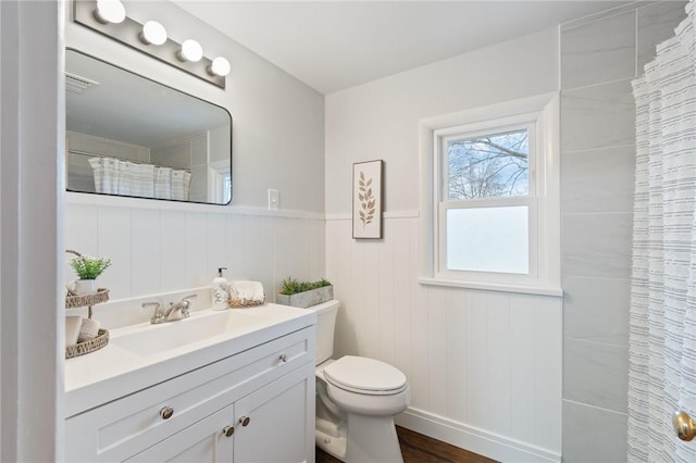 bathroom featuring toilet, a shower with shower curtain, and vanity