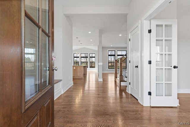 corridor featuring dark wood-type flooring, french doors, and decorative columns