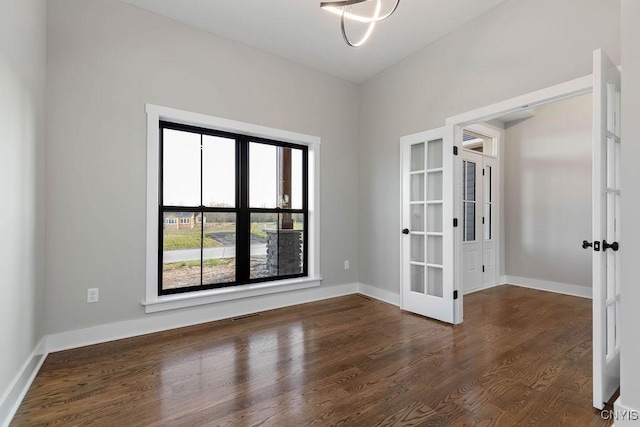 empty room featuring dark hardwood / wood-style flooring and french doors