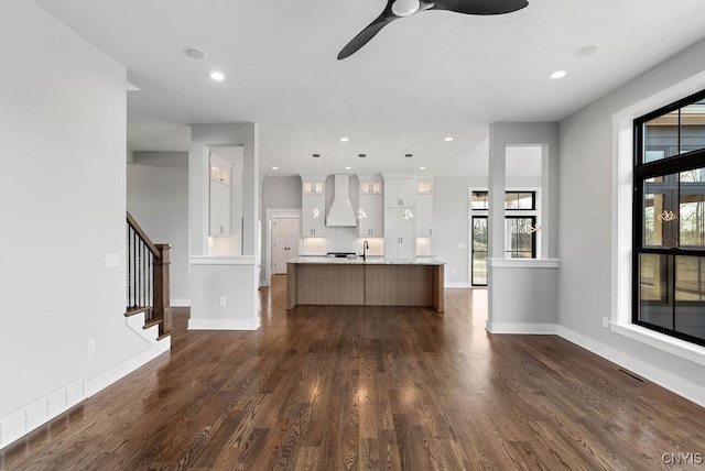 unfurnished living room with ceiling fan, dark hardwood / wood-style flooring, and sink