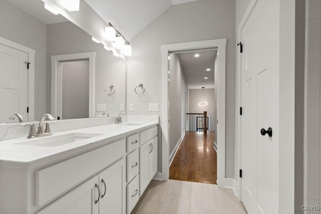 bathroom featuring vanity, tile patterned flooring, and vaulted ceiling