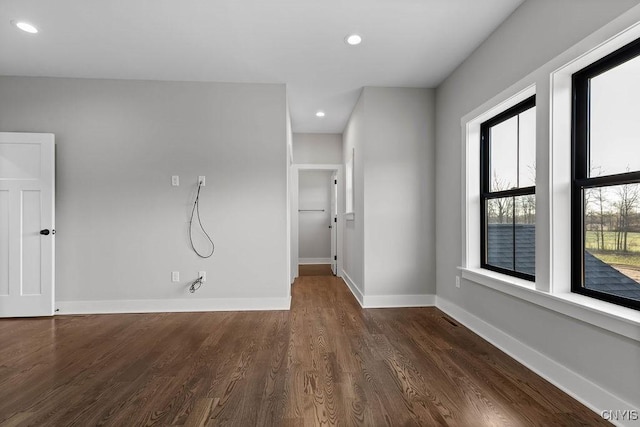 spare room featuring plenty of natural light and dark hardwood / wood-style floors