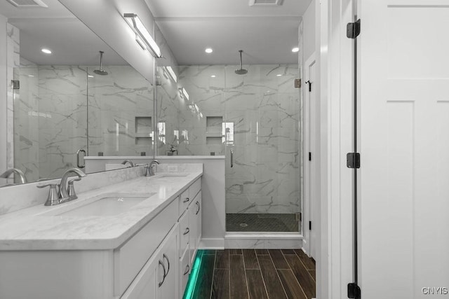 bathroom with a shower with door and vanity