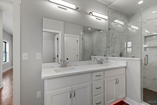 bathroom featuring a shower with door, vanity, and wood-type flooring