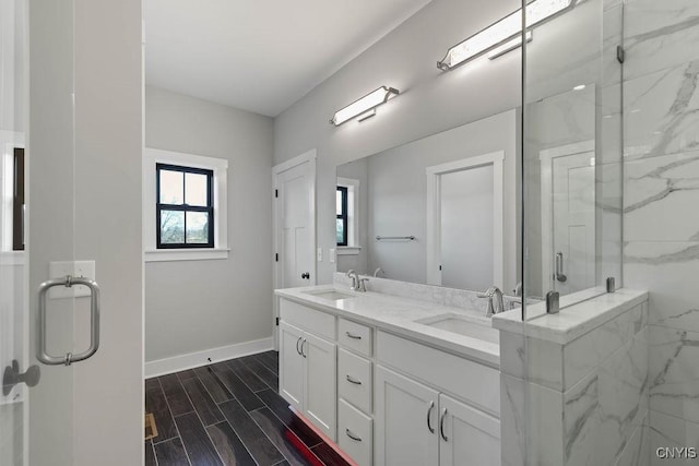 bathroom featuring a shower with door and vanity