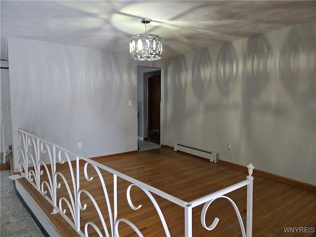 interior space featuring hardwood / wood-style floors, a baseboard radiator, and a chandelier