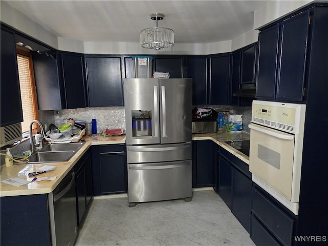 kitchen with sink, an inviting chandelier, decorative backsplash, hanging light fixtures, and black appliances