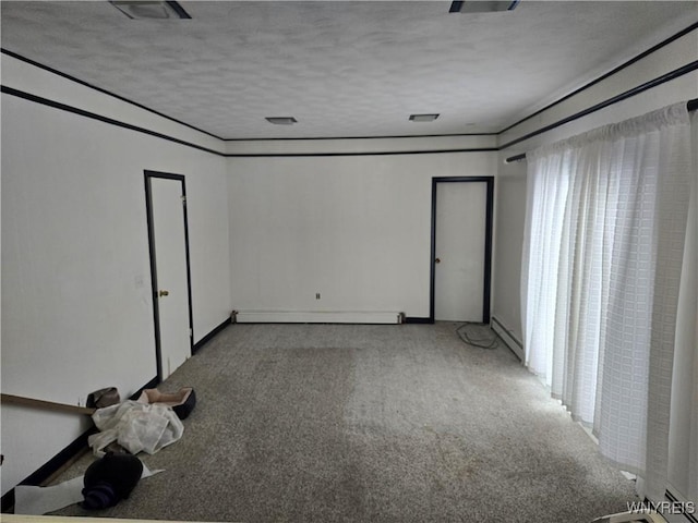 carpeted empty room with a baseboard radiator and a textured ceiling