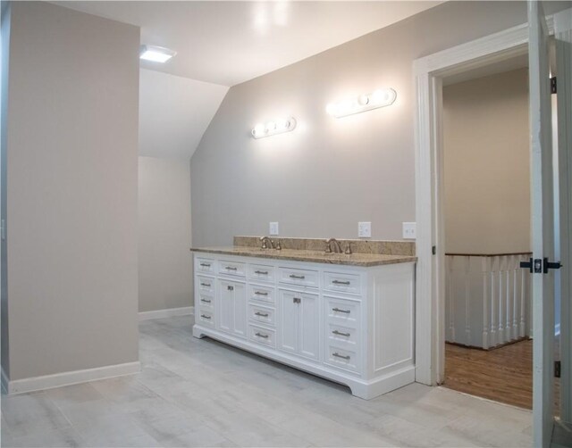 bathroom featuring vaulted ceiling and vanity