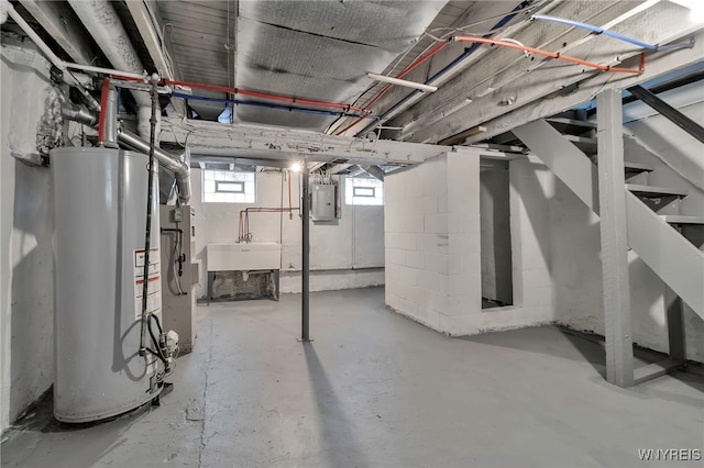 basement with electric panel, sink, and gas water heater