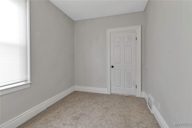 unfurnished room featuring light carpet