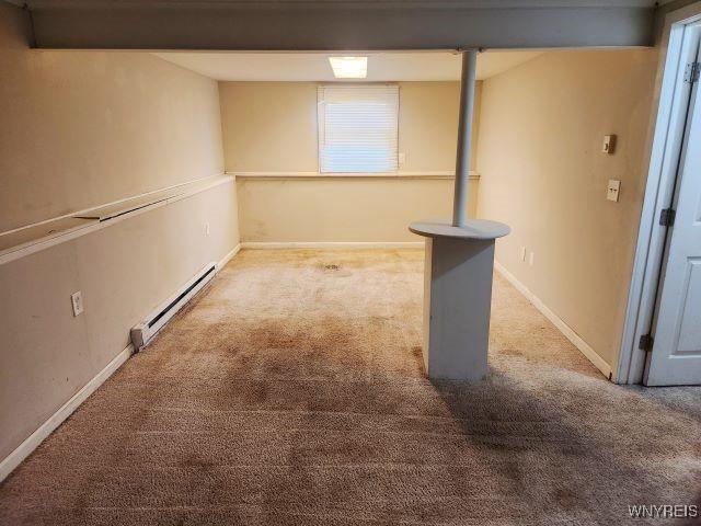 basement with light colored carpet and a baseboard radiator