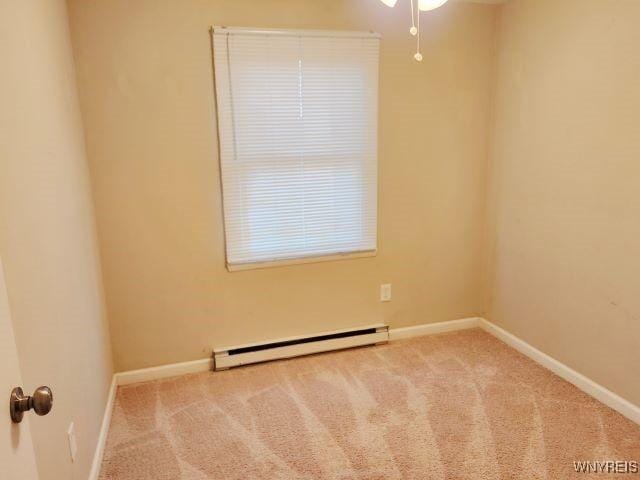 carpeted spare room featuring baseboard heating