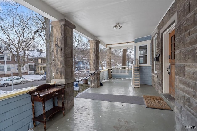 snow covered patio featuring covered porch