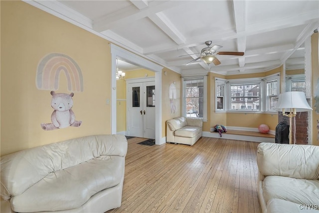 living room with light wood-type flooring, ceiling fan, ornamental molding, french doors, and beam ceiling