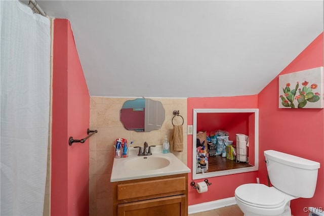 bathroom with lofted ceiling, toilet, and vanity